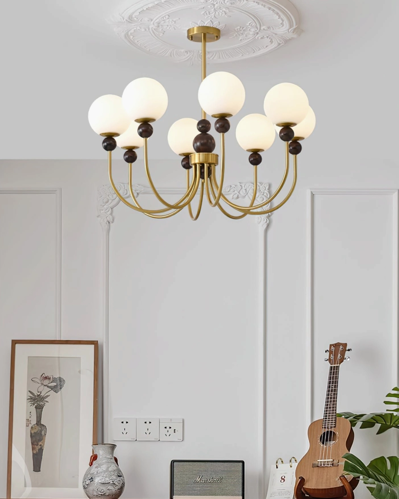 Modern glass chandelier with brass frame overhead view in French vintage living room with wall art
