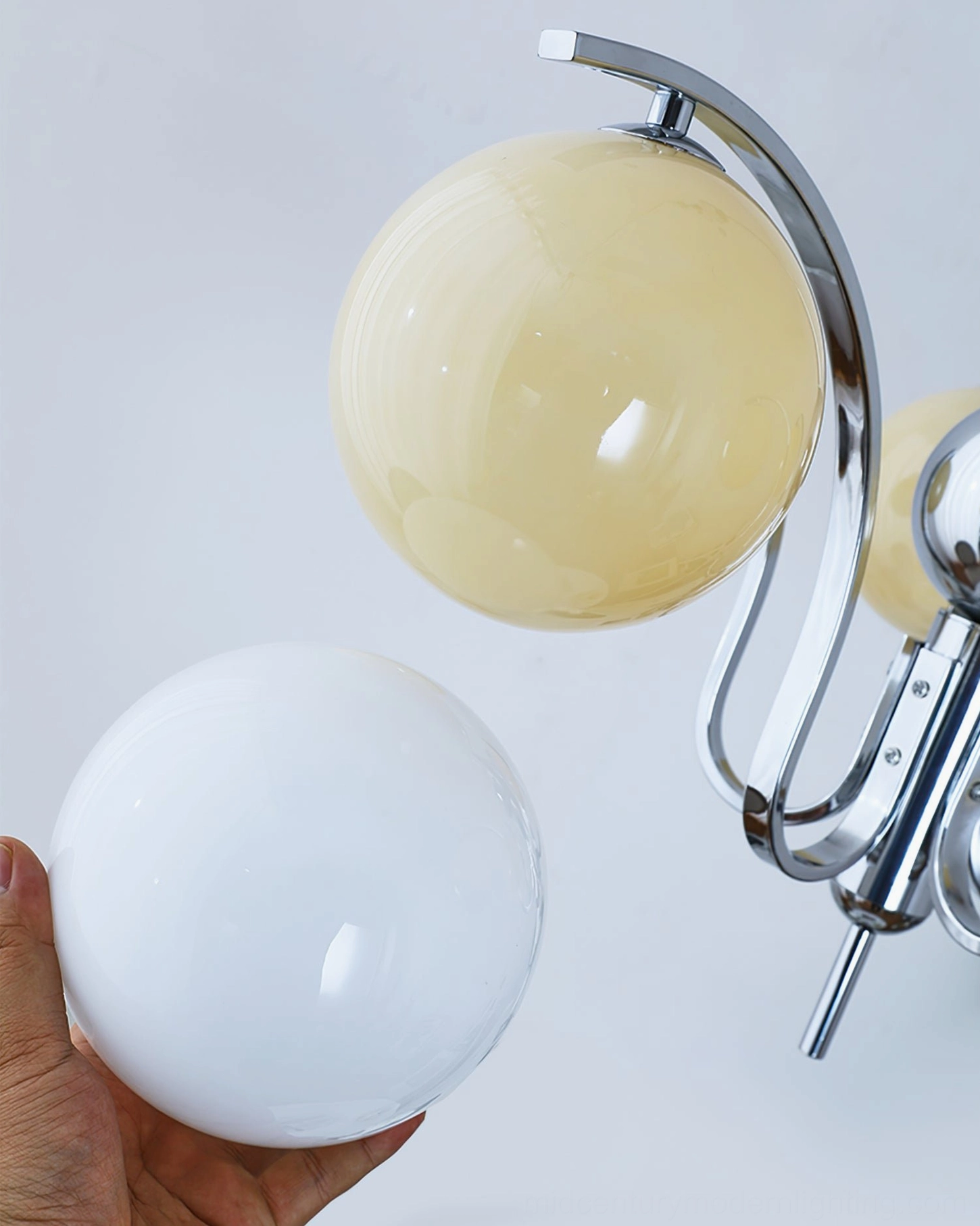 Glass globe chandelier spherical shade construction and chrome frame joinery close-up
