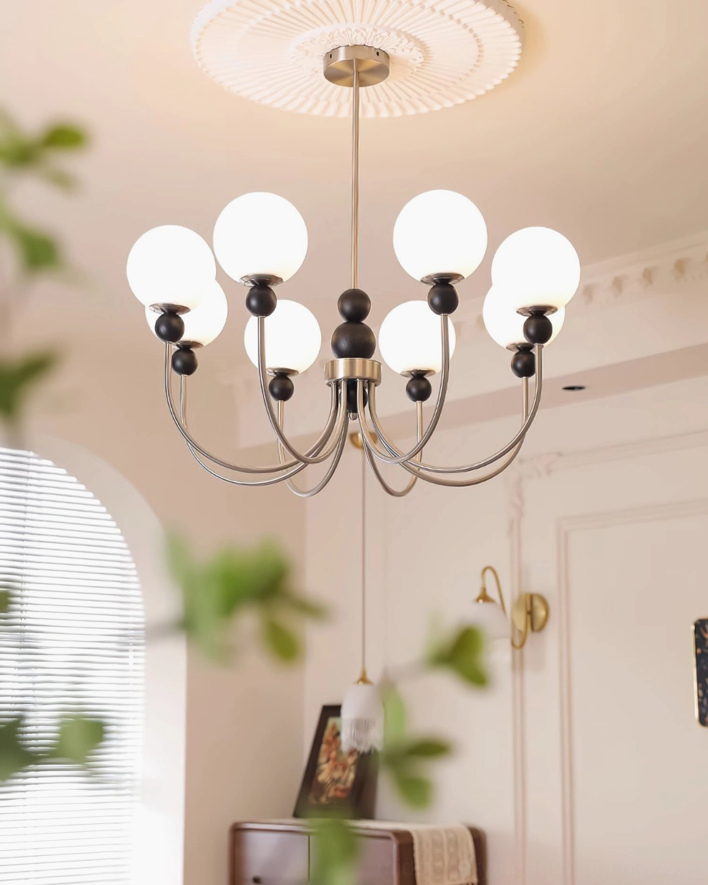 Contemporary glass chandelier with dark bronze metal frame and frosted shades in cozy vintage home