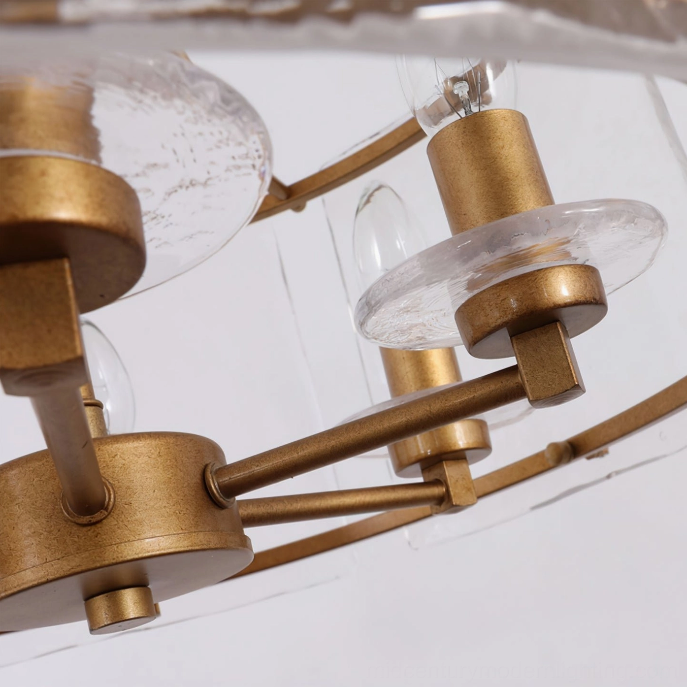 Glenn Round Chandelier lamp base detail - antique brass candle sockets with clear glass accents