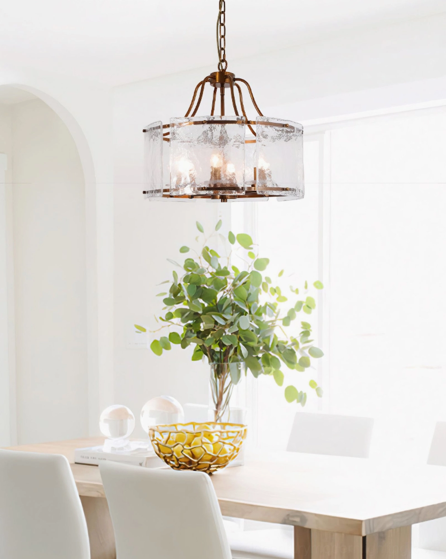 Glenn Round Chandelier in modern dining room - warm brass chandelier above white dining table