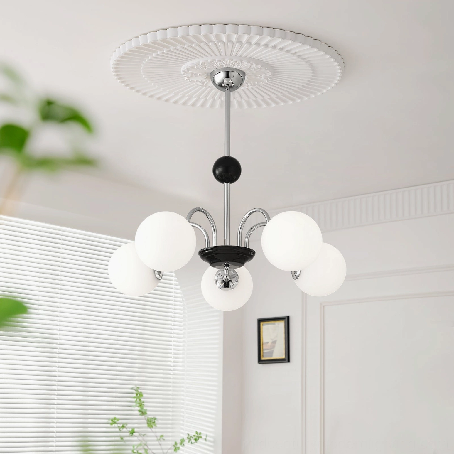 Ceiling-mounted globe chandelier with decorative ceiling rose installed in minimalist white room with window blinds