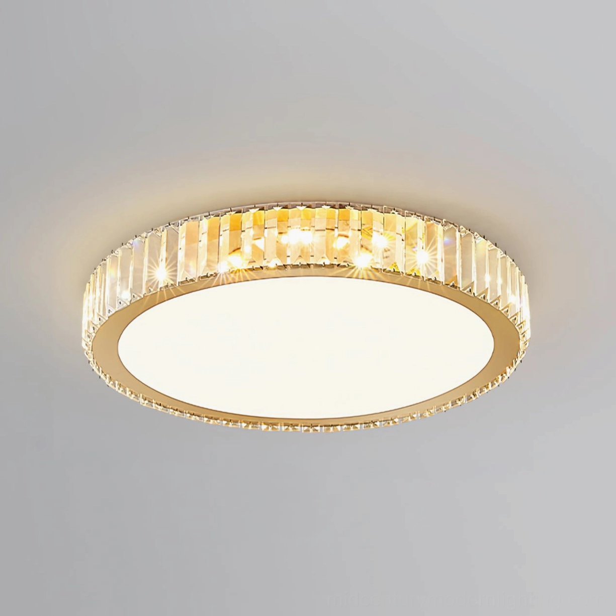 Lit round crystal ceiling lamp glowing warm golden light against white ceiling