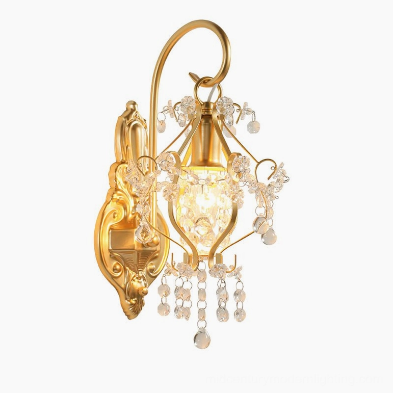Gold crystal wall sconce illuminated front side view showing bulb glow through crystal tassels in studio setting