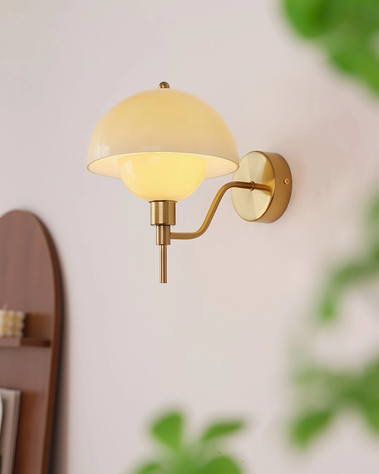 Gold finish anchored orb wall lamp mounted in home interior showing finish and glass shade combination