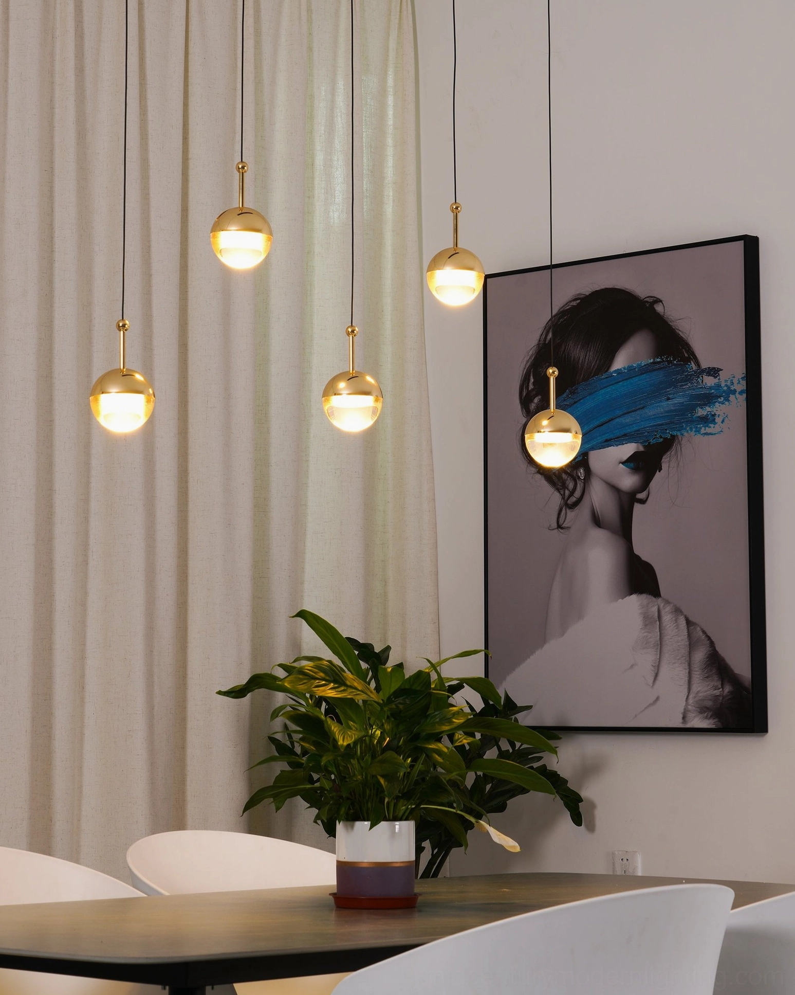 Gold spherical pendant lights in cozy minimalist dining room with wall artwork contemporary lighting