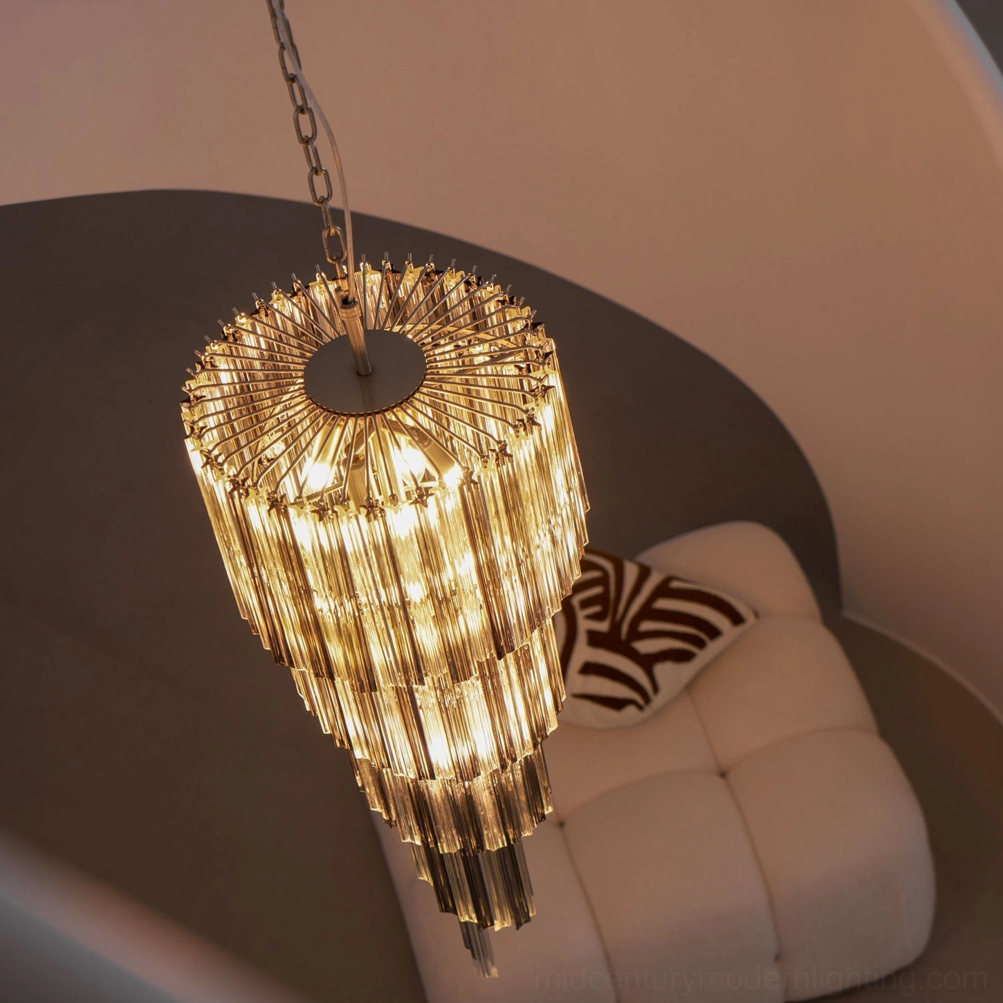 Golden tiered chandelier with amber glass in warm cozy living room, low angle view with gold metal frame