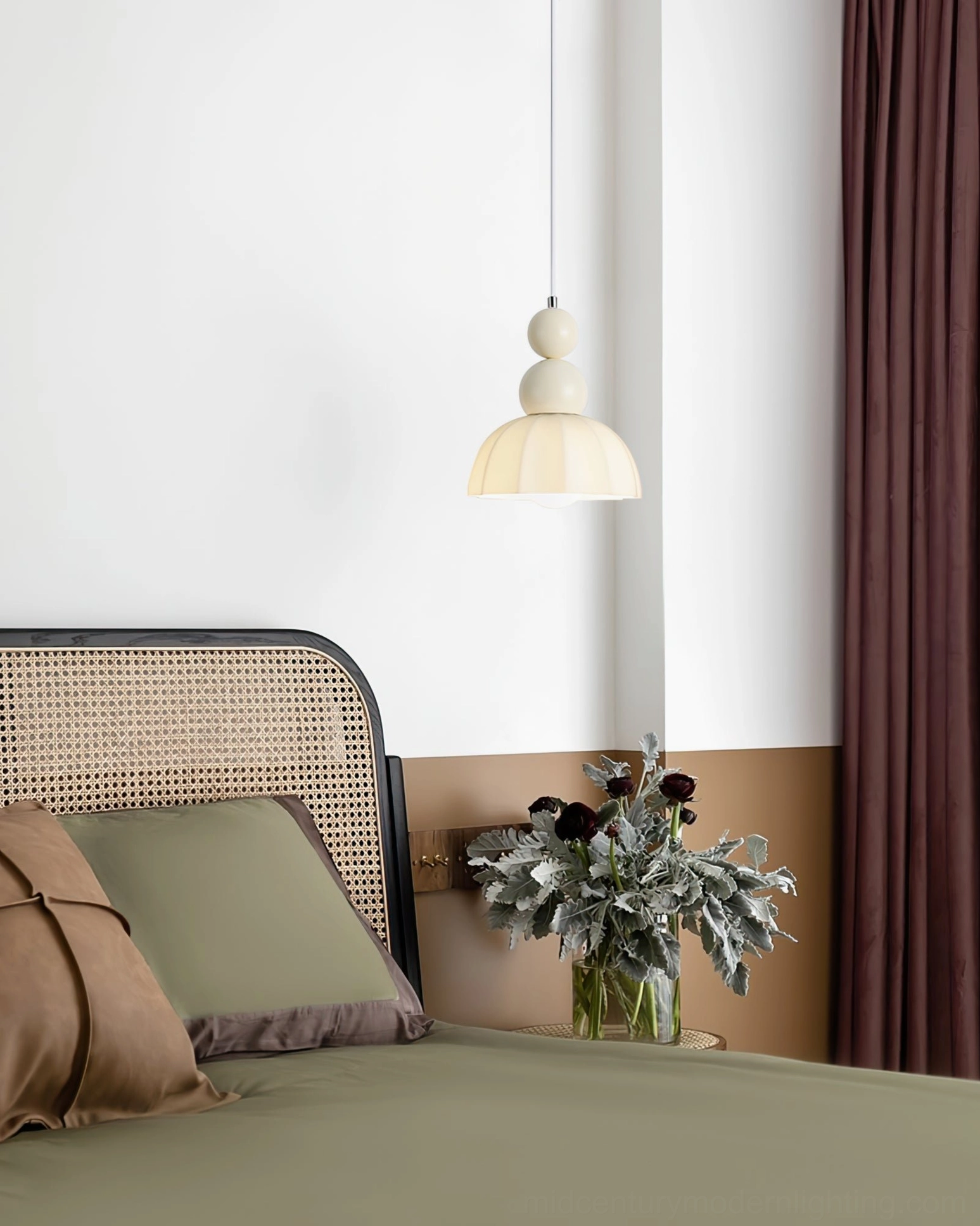 Single gourd bubble pendant lamp above green upholstered headboard and rattan bed frame, bedroom ambiance lighting