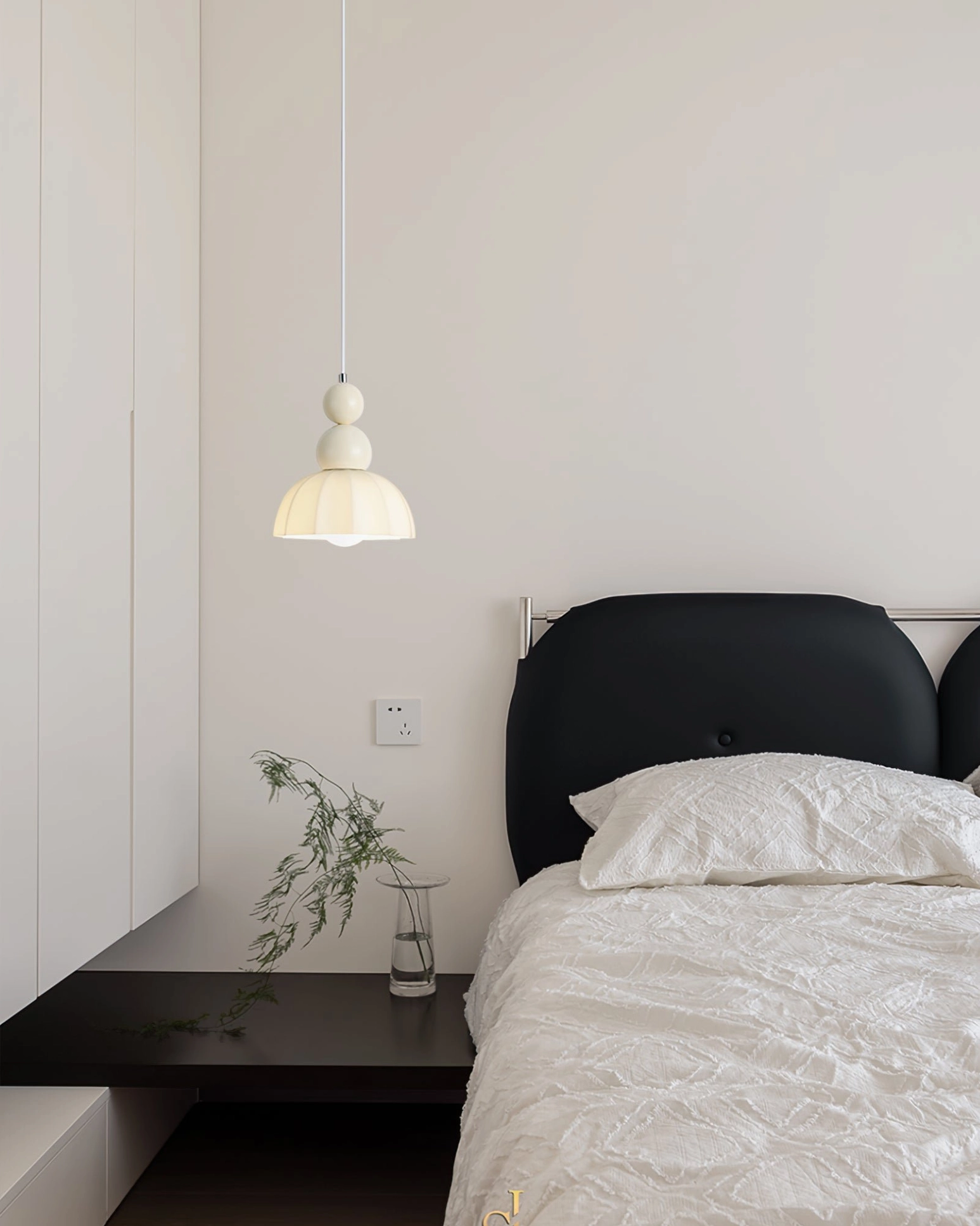 Gourd bubble pendant fixture above modern bedroom nightstand with black upholstered headboard and shelf styling