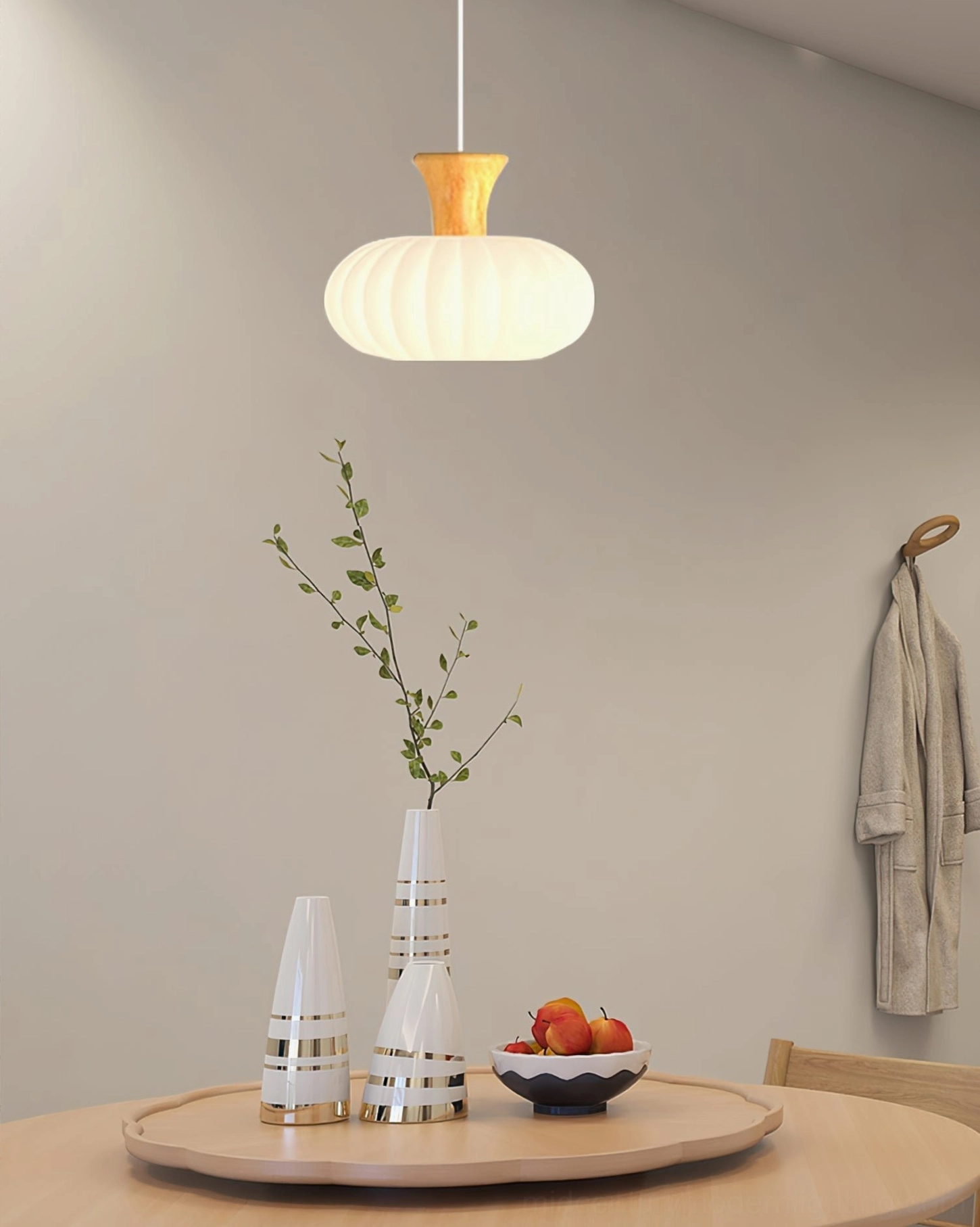 Round fluted pendant light above dining nook with minimalist table setting and wall decor