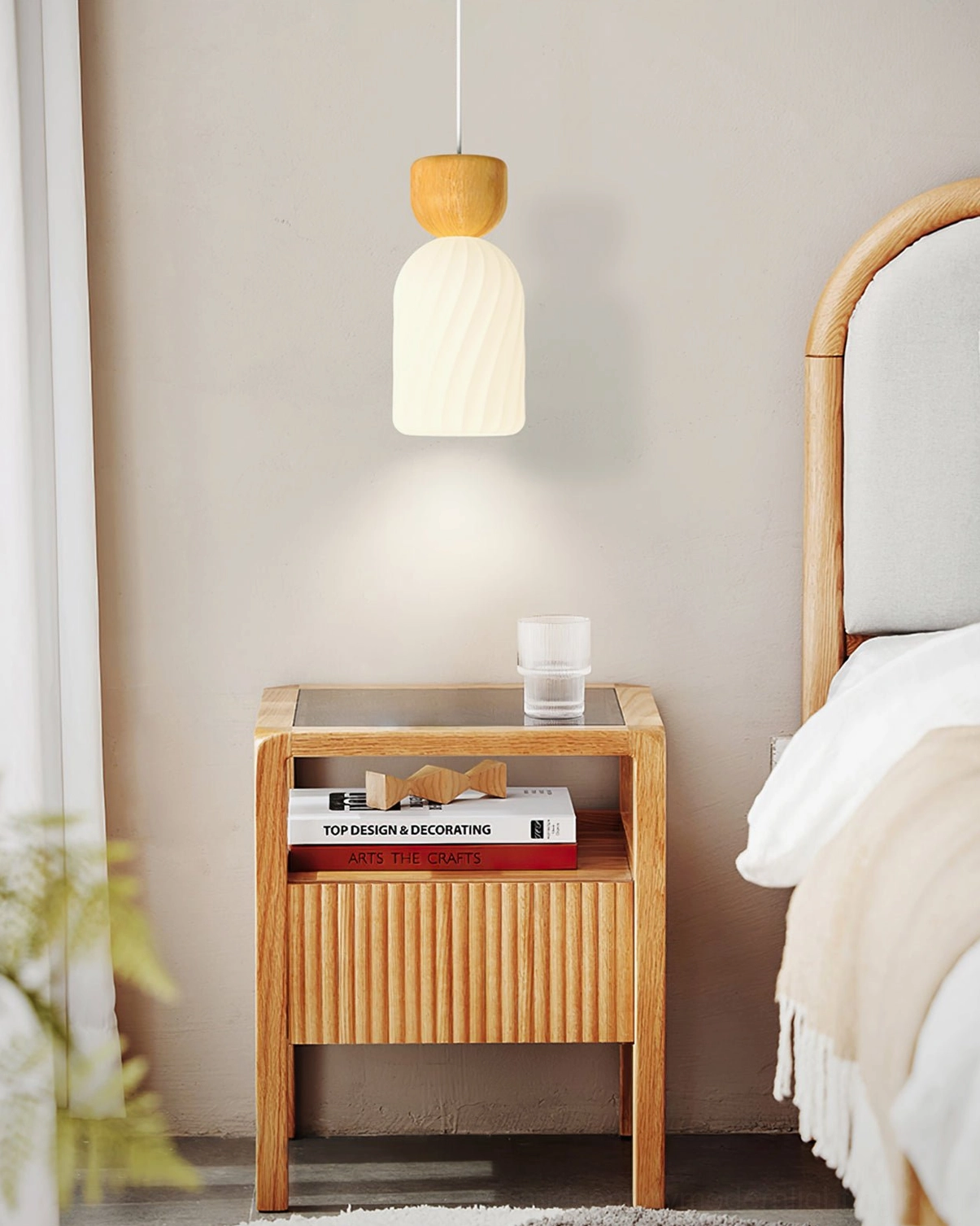 Cylindrical ribbed pendant light in bedroom with upholstered headboard and wood nightstand