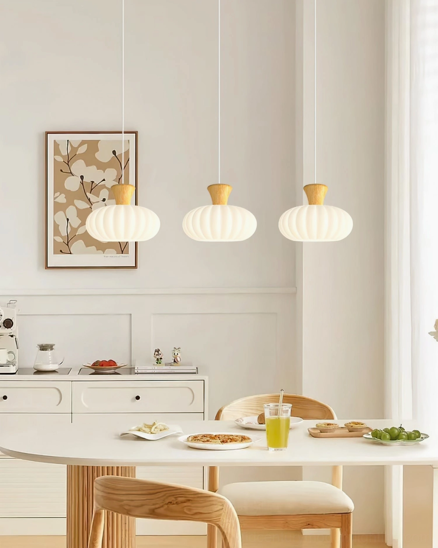Set of three round fluted pendant lights in cozy dining room with tableware and storage cabinet