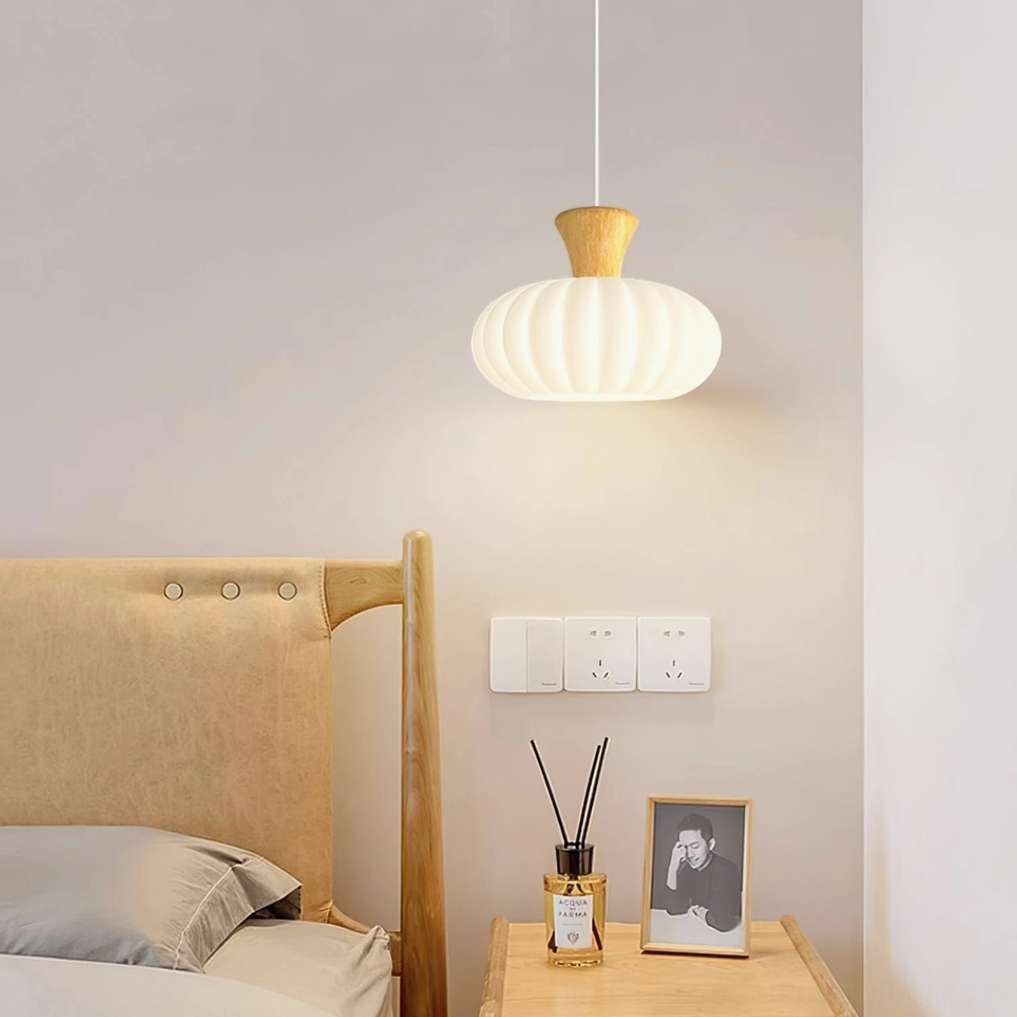 Round fluted pendant lamp above wooden headboard in contemporary bedroom setting