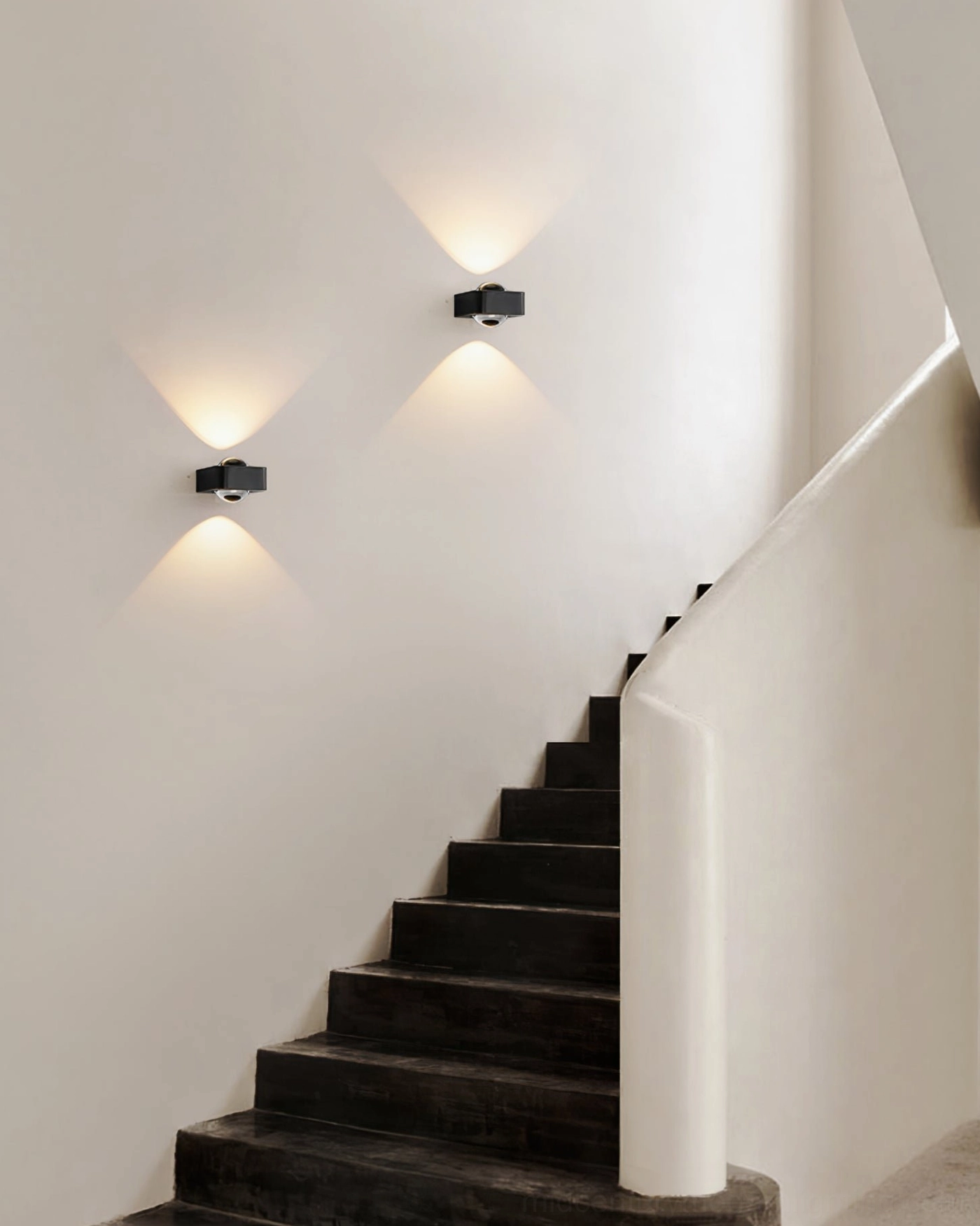 Pair of black Grace wall sconces illuminating minimalist staircase hallway