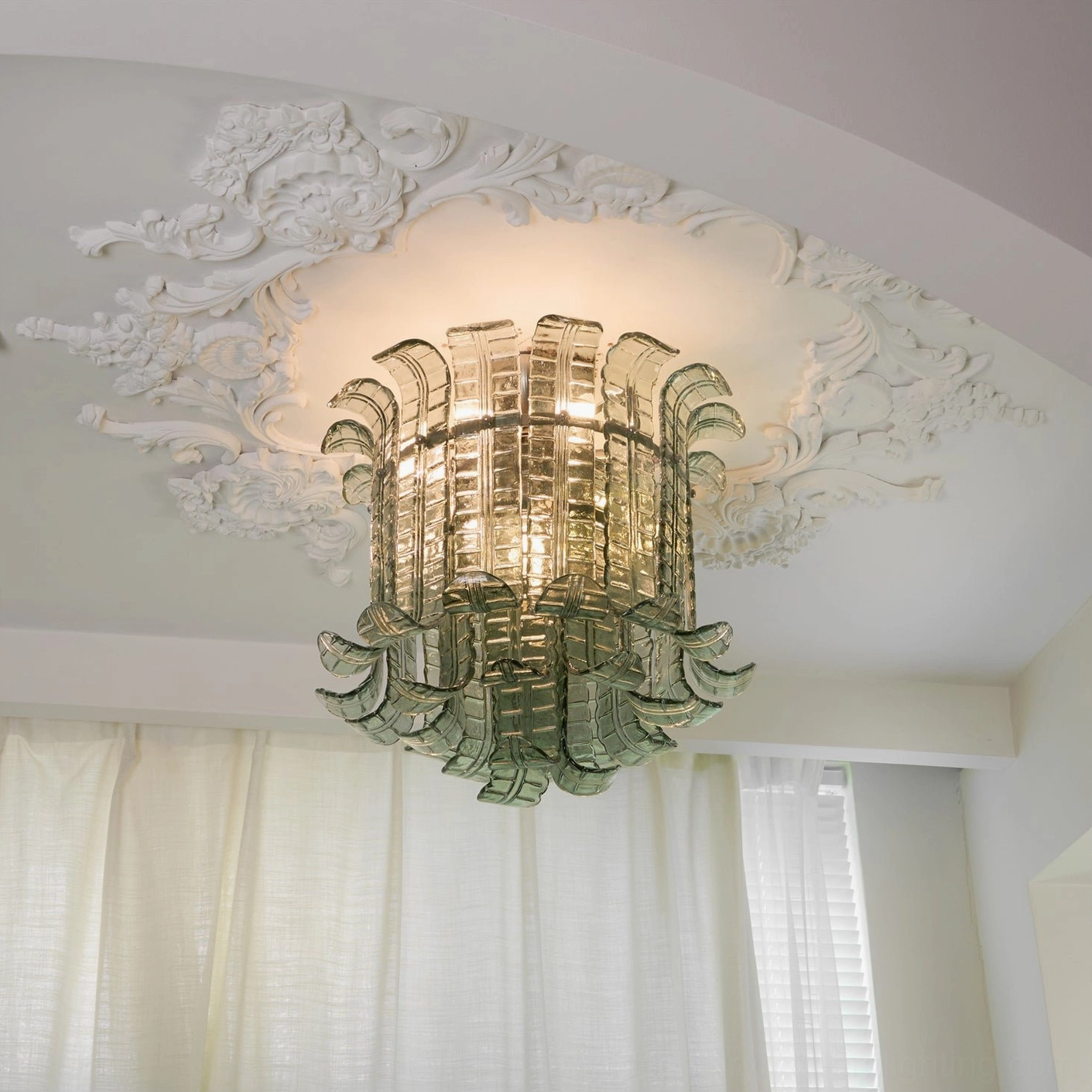 Two-tone gradient glass ceiling fixture, scalloped leaf design, bedroom installation with ornate ceiling medallion