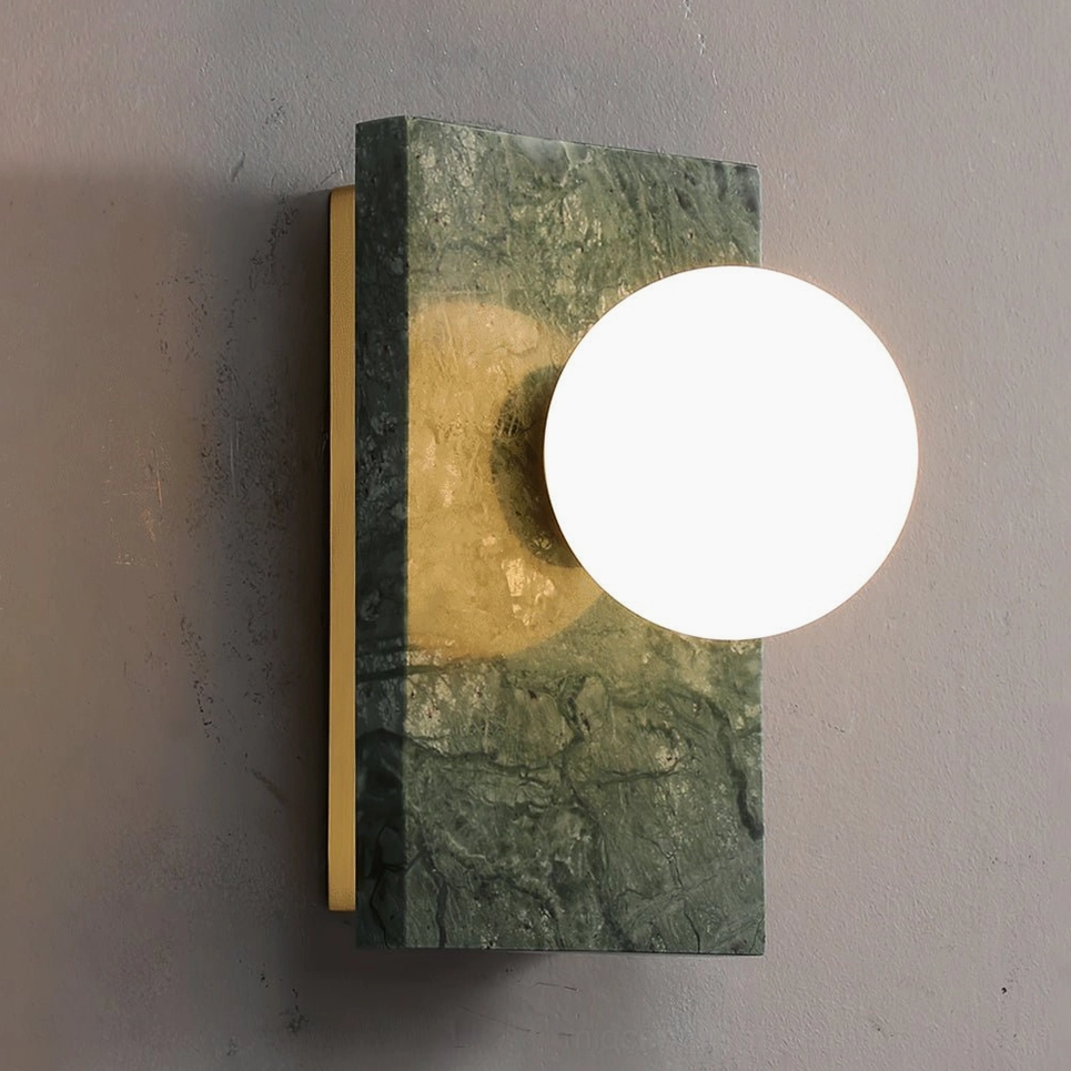 Close-up frontal view of Lan wall sconce showing large frosted glass diffuser and green marble base detail