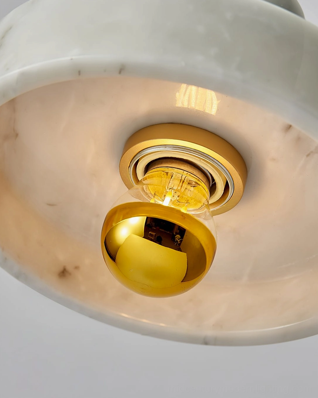Green marble pendant light showing natural geological pattern and warm illumination effect