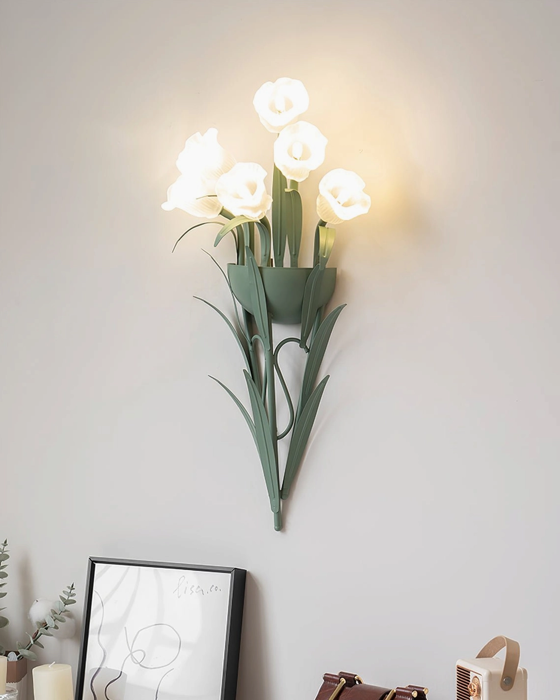 Matte green metal botanical wall lamp with warm LED lighting, minimalist wall arrangement