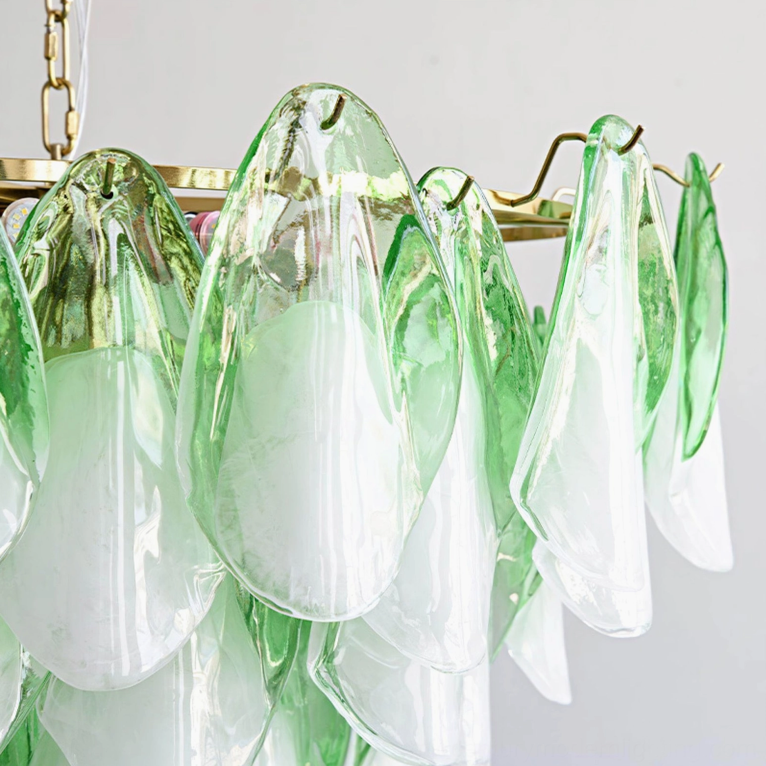 Macro view of green and white gradient glass petal construction on foliage chandelier
