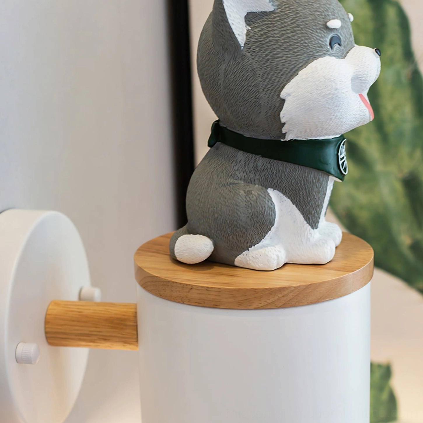 Grey Shiba Inu wall lamp close-up side view with green scarf detail on home wall with cactus painting