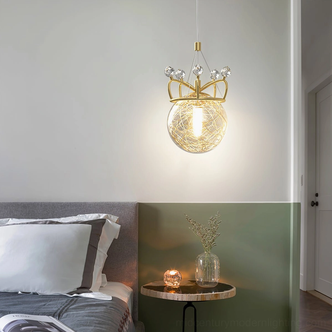 Hand-blown glass crown pendant in bedroom with green accent wall and round bedside table