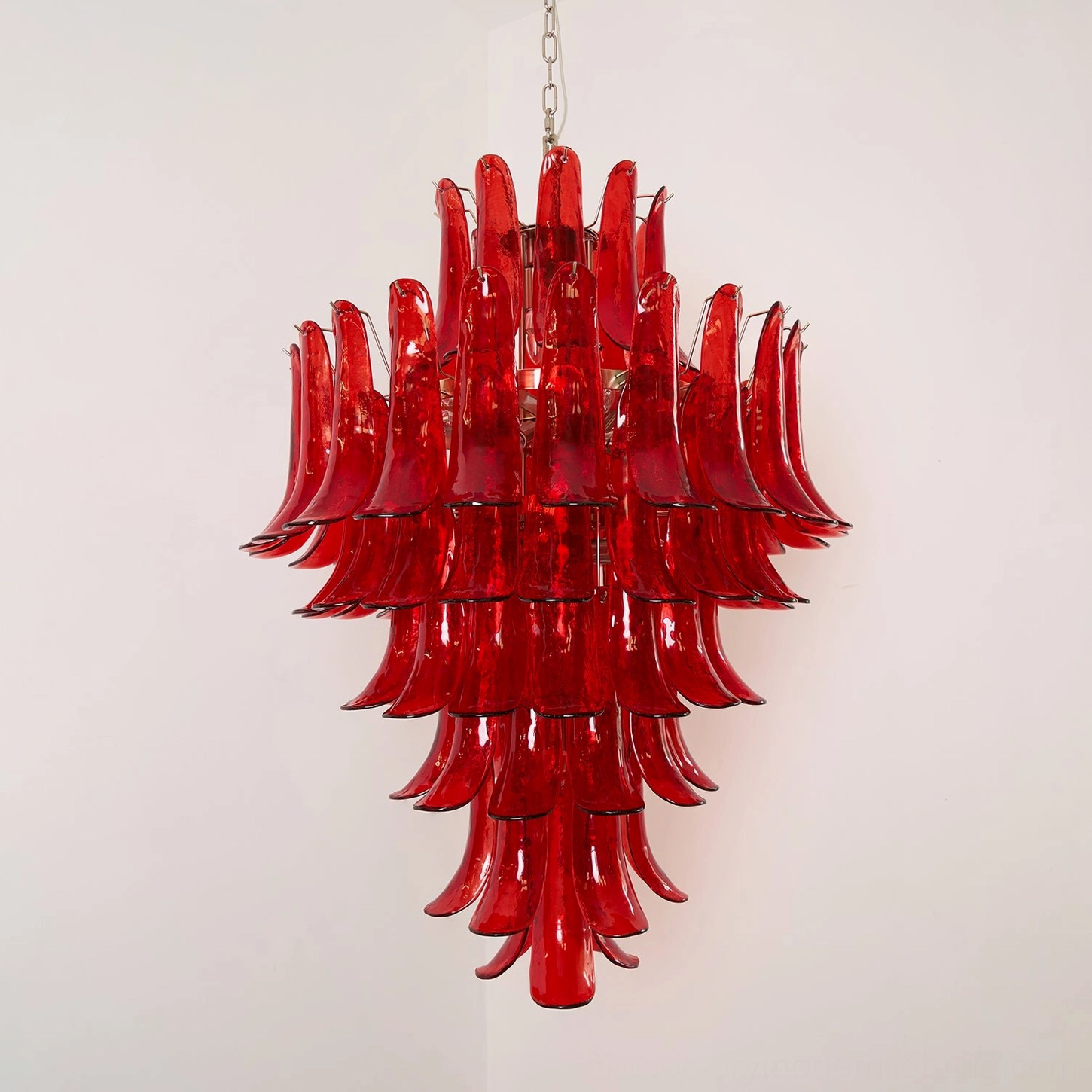 Front-facing view of hand-blown Murano glass chandelier with stacked translucent red petals and polished gold metal accents