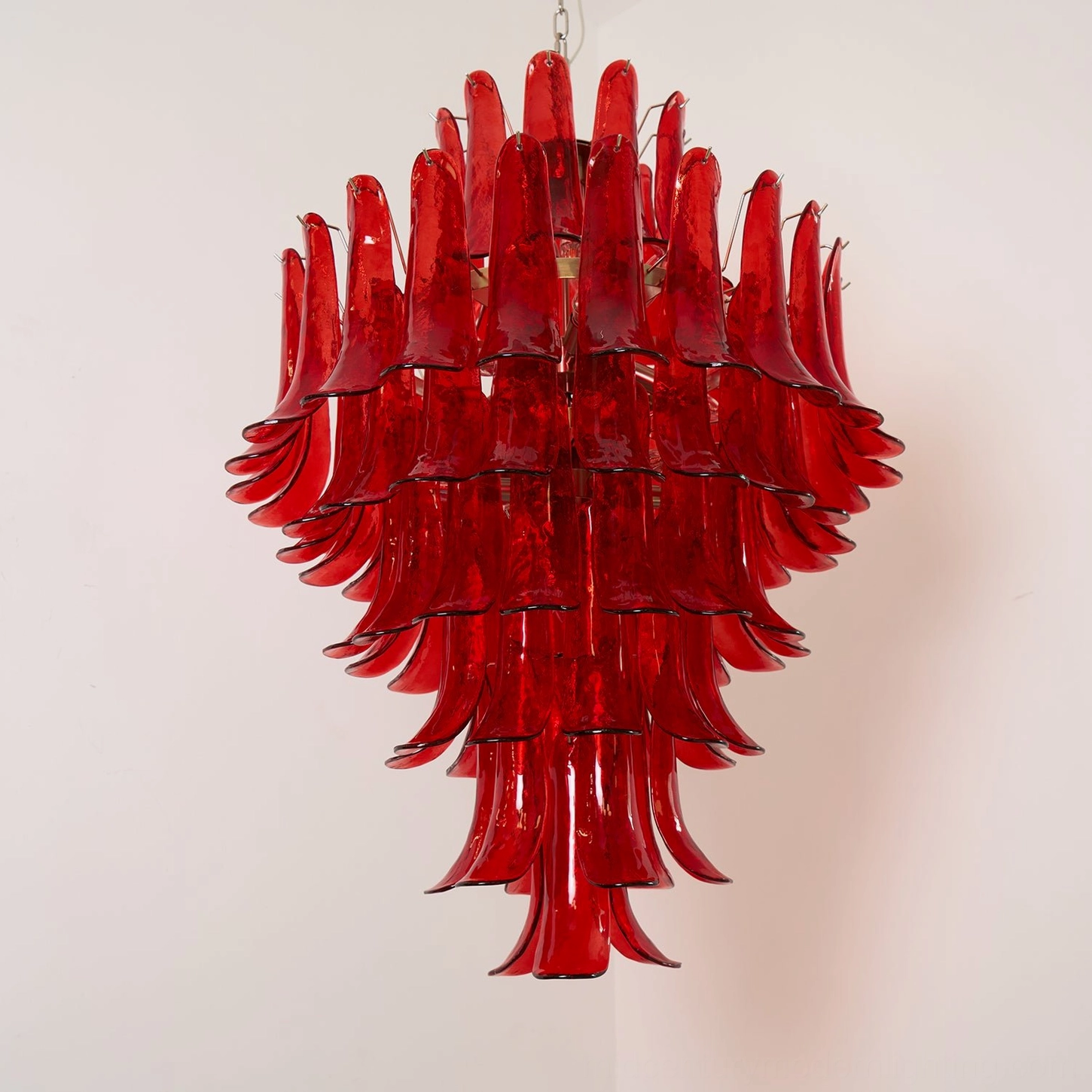 Hand-blown Murano glass chandelier in vibrant red with cascading petal layers, showing color depth and light-refracting glass quality