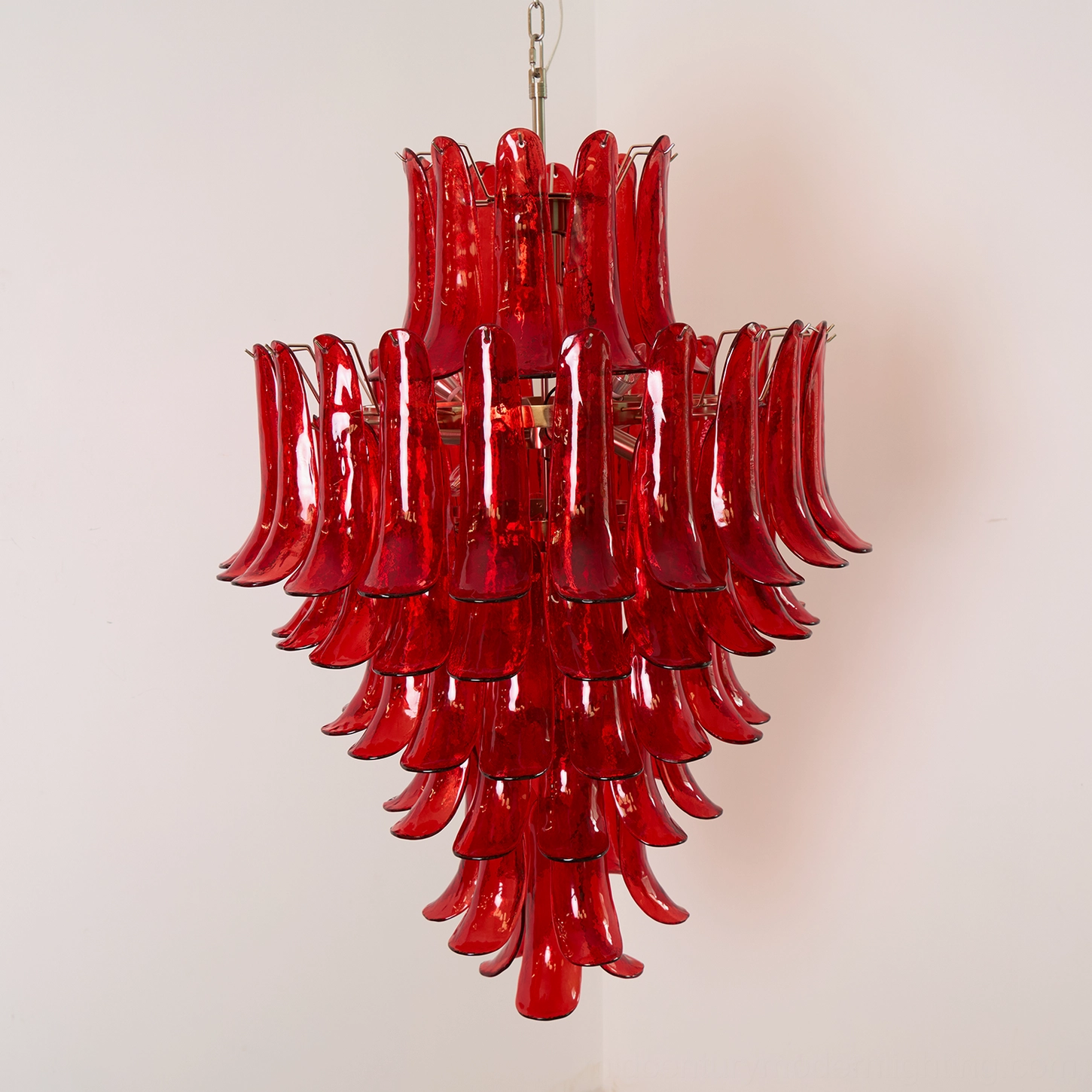 Complete view of hand-crafted Murano glass chandelier in red, displaying symmetrical petal structure and professional hanging chain installation