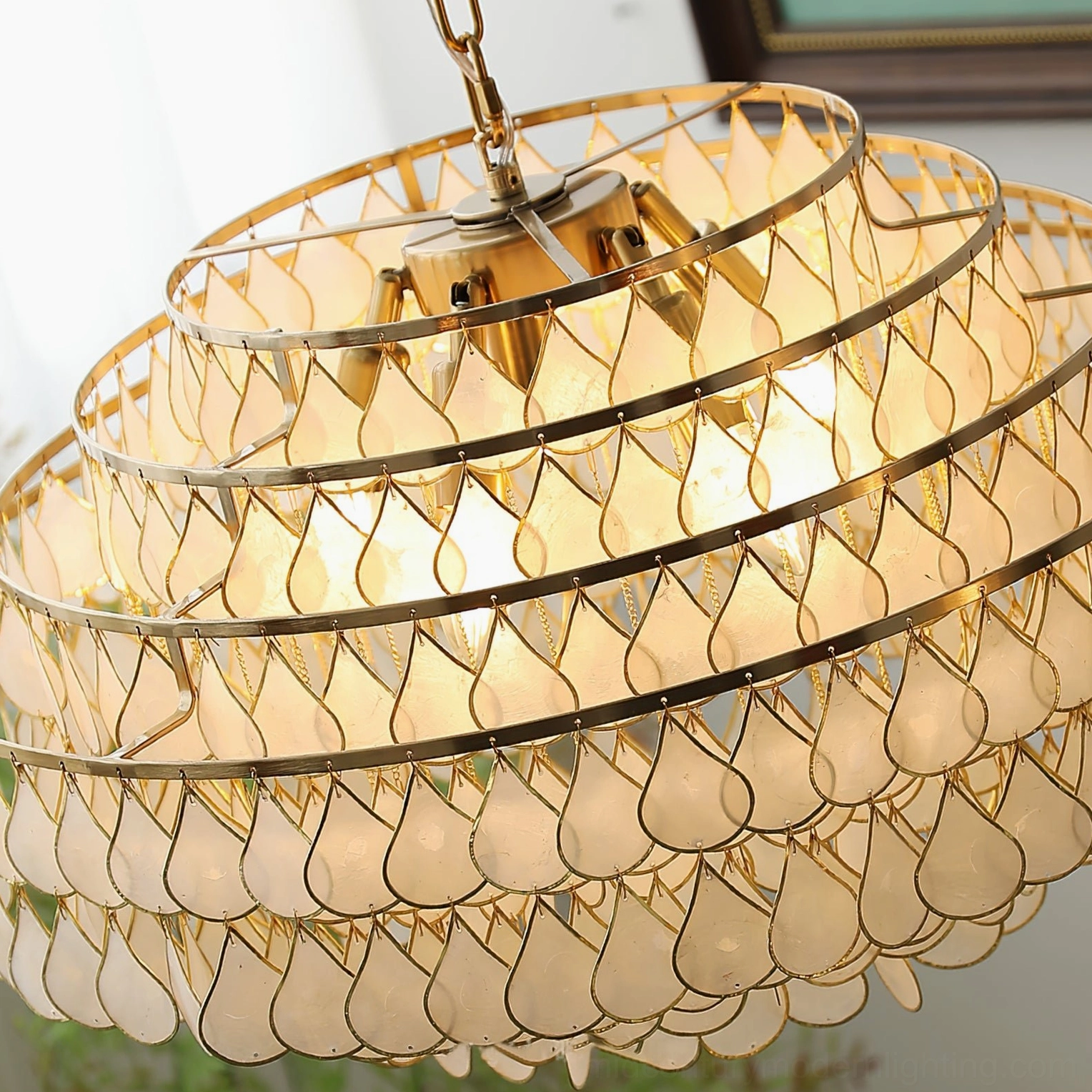 Handcrafted tiered shell pendant lamp showing fine craftsmanship, genuine shell material with organic translucency and warm light diffusion