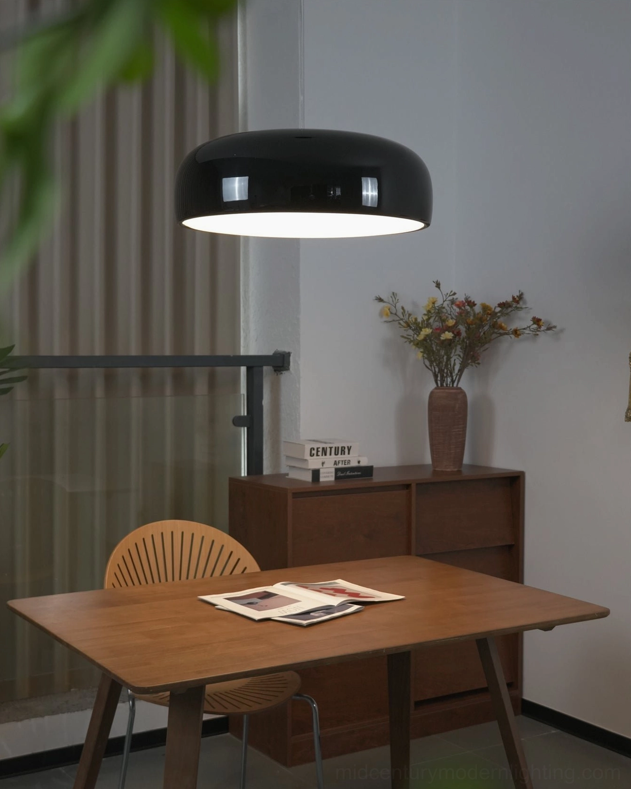 Glossy black Harper pendant above minimalist wooden dining corner table, sleek aluminum shade with coordinated ceiling canopy installation