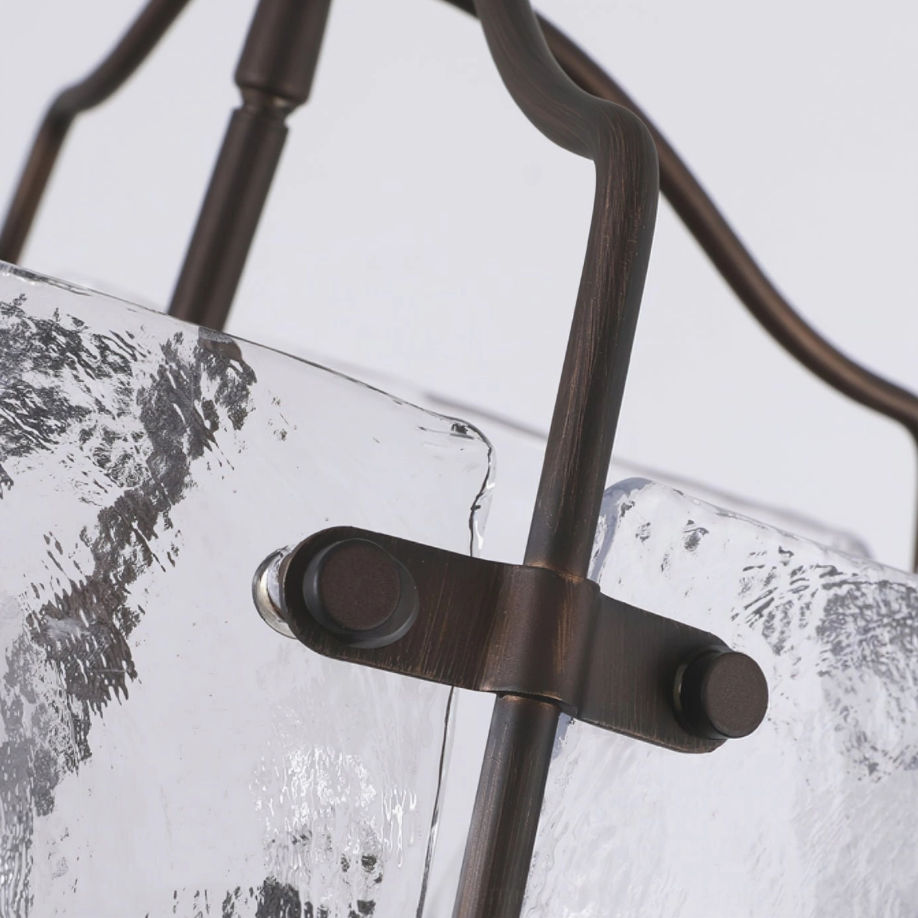 Close-up detail of Harrow chandelier showing hand-textured rippled glass and dark bronze metal fasteners