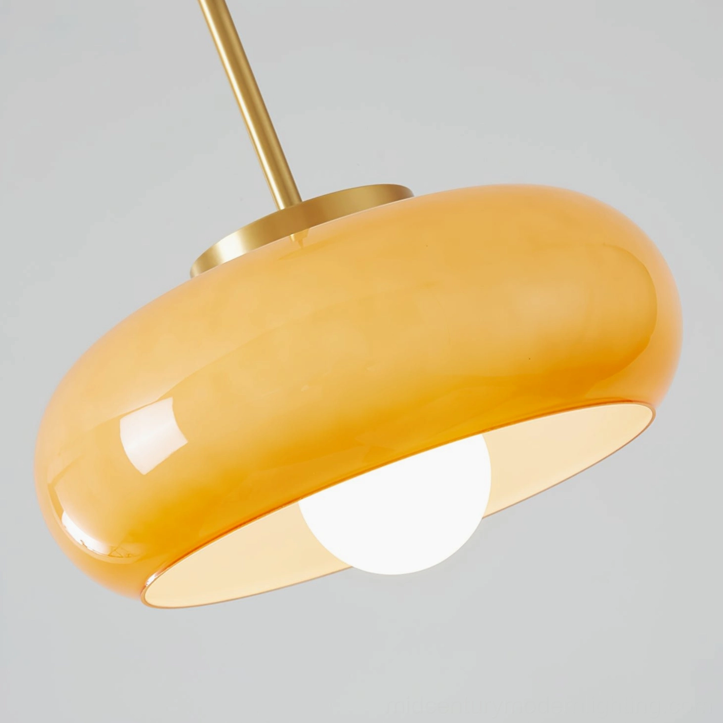 Harvey pendant light interior detail showing globe bulb with polished glossy amber glass surface, low-angle view