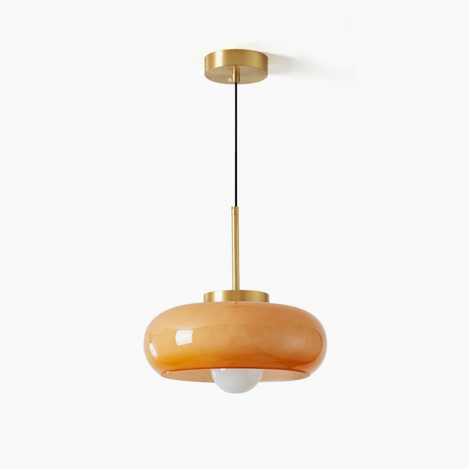 Harvey mid-century modern pendant light with warm amber glass shade and brass metal fixture, front view studio photography