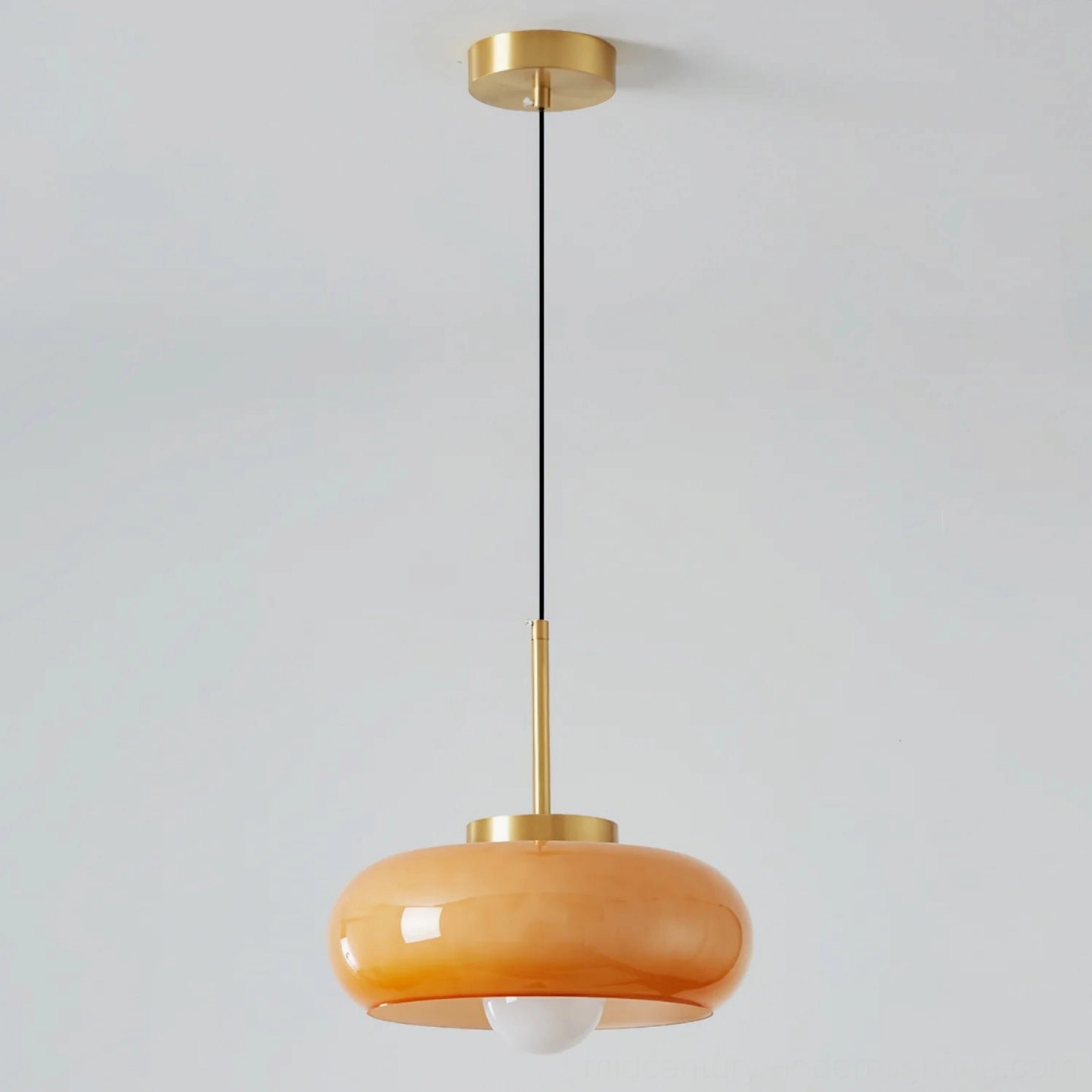 Harvey pendant light bottom view showing exposed Edison bulb inside smooth amber glass dome, retro vintage style