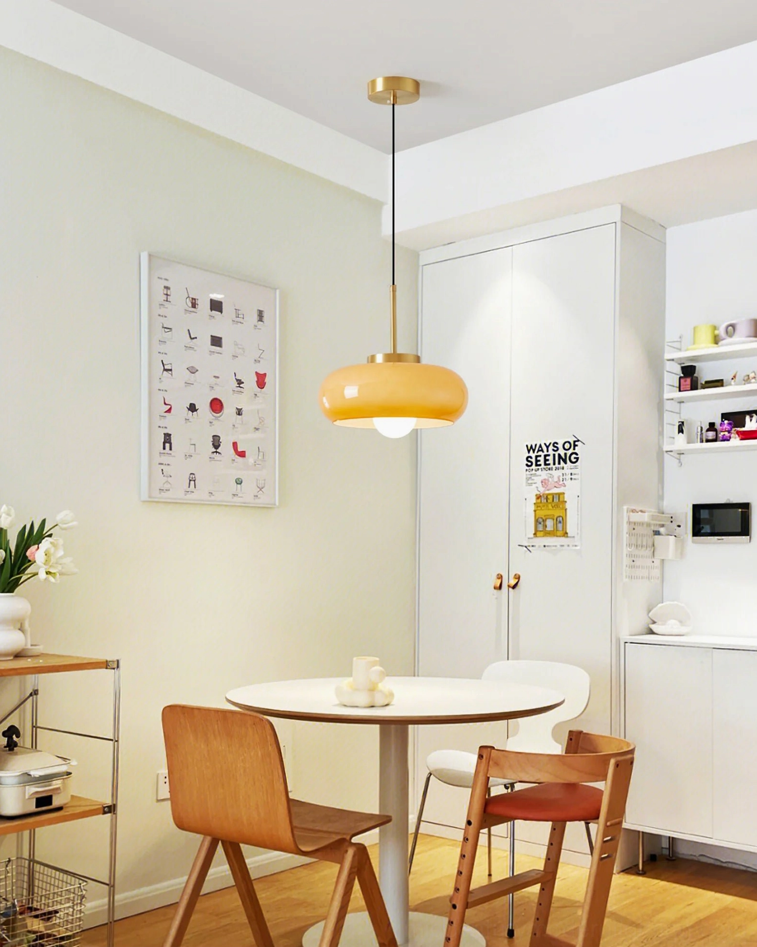 Harvey amber glass pendant light installed in modern Scandinavian dining nook, warm ambient lighting in home interior