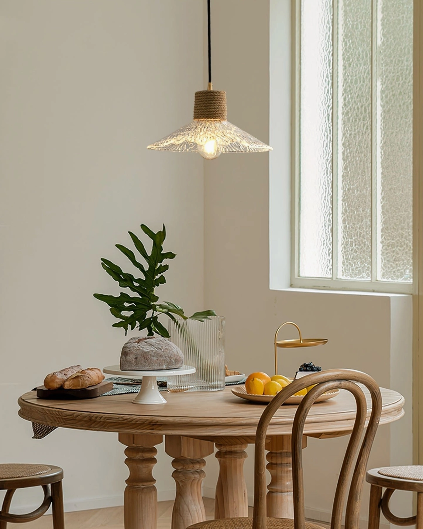 Hemp rope glass pendant fixture hanging in farmhouse dining room with natural light, showing rustic modern decor integration