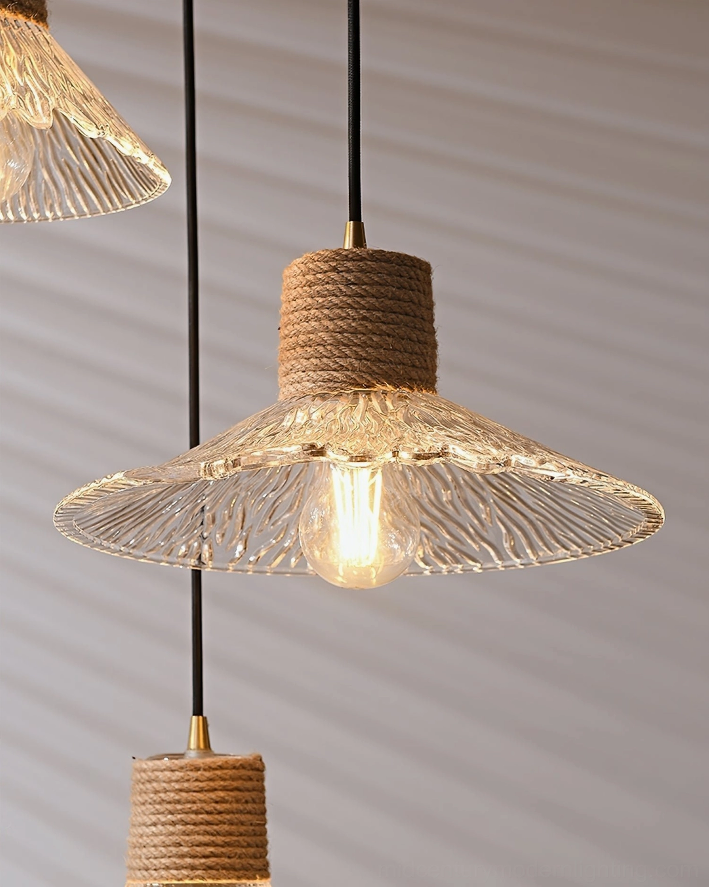 Hemp rope glass pendant fixture detail showing metal hardware and rope attachment point, construction quality view