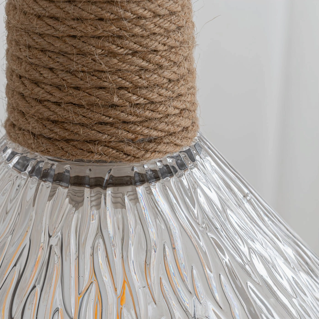 Hemp rope glass pendant lamp in rustic boho interior, warm opaque glass diffuser and natural fiber rope design