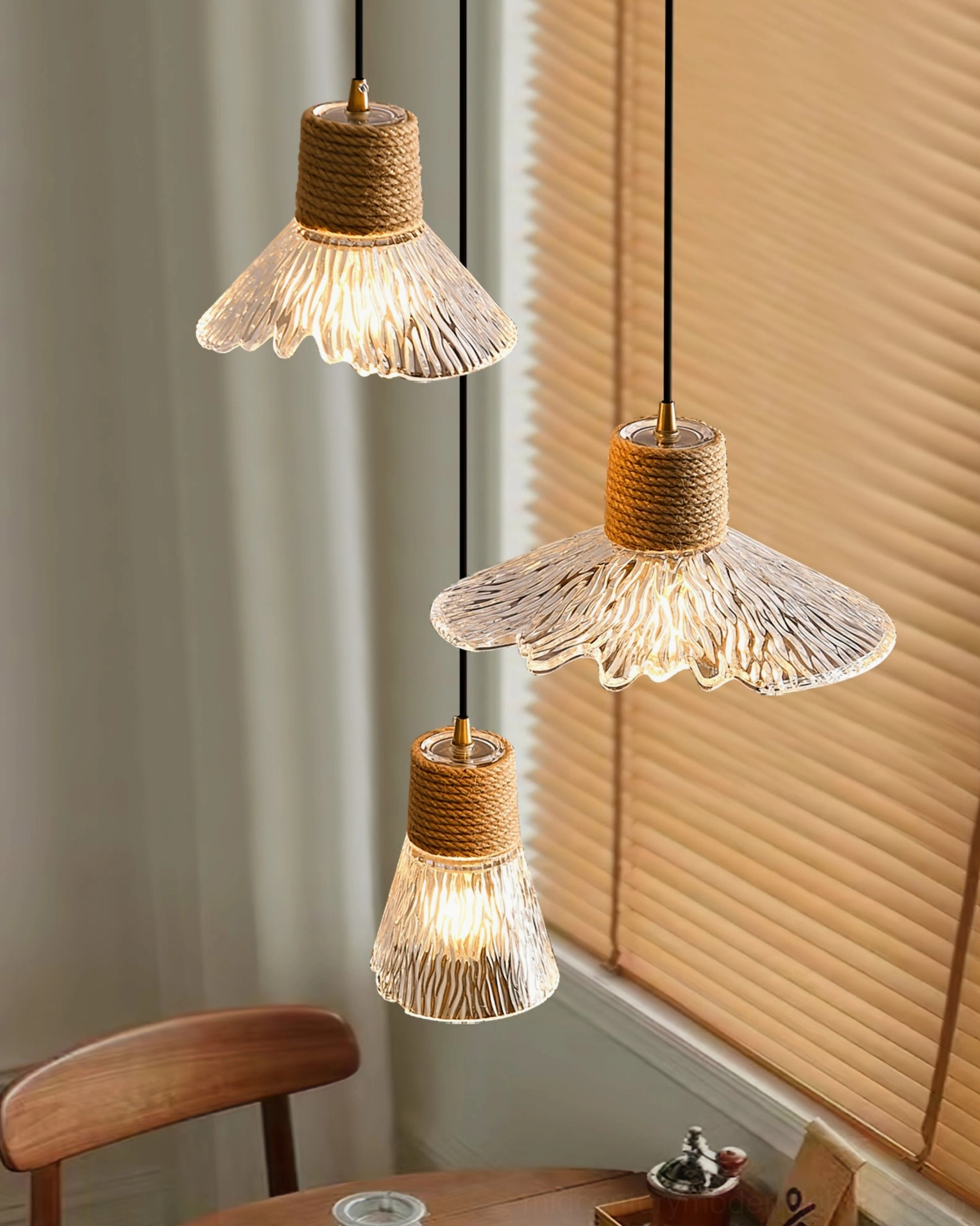 Side-by-side comparison of two hemp rope glass pendant lamps with different diameters near window nook, warm natural lighting