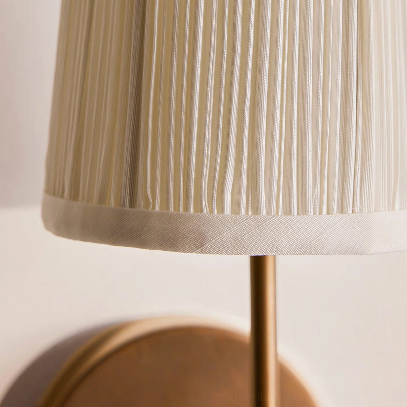 Henley wall sconce side angle detail showing brass stem and vertical pleated linen shade construction