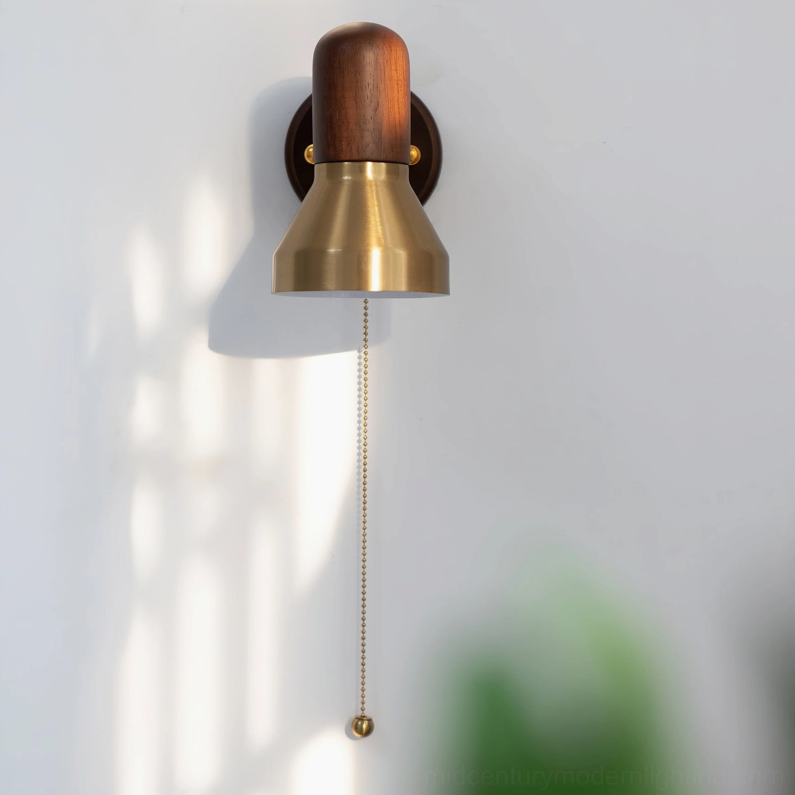 Overhead view of retro pull-chain wall sconce with minimalist brass and wood design