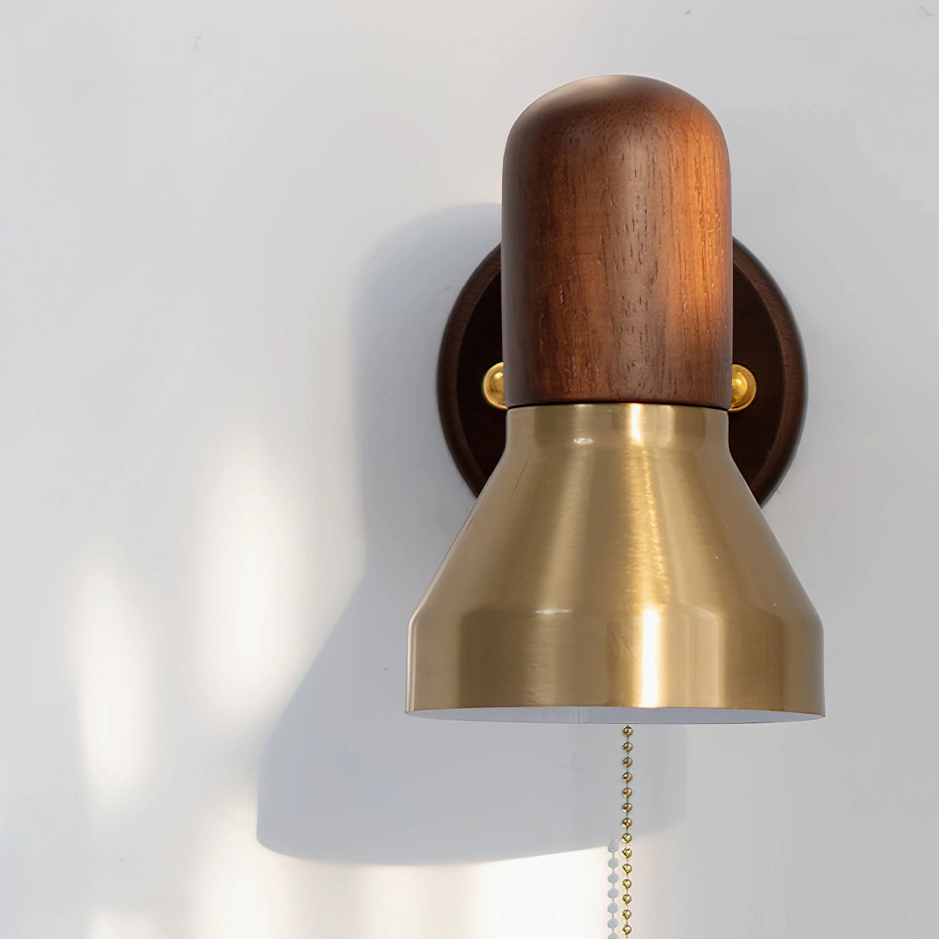 Vertical front low-angle view of Heron wall sconce showcasing dual-tone brass and wood silhouette