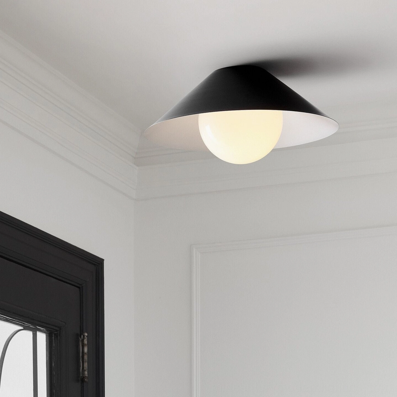 Matte black Hood Coolie geometric ceiling mount above residential entryway with dark door