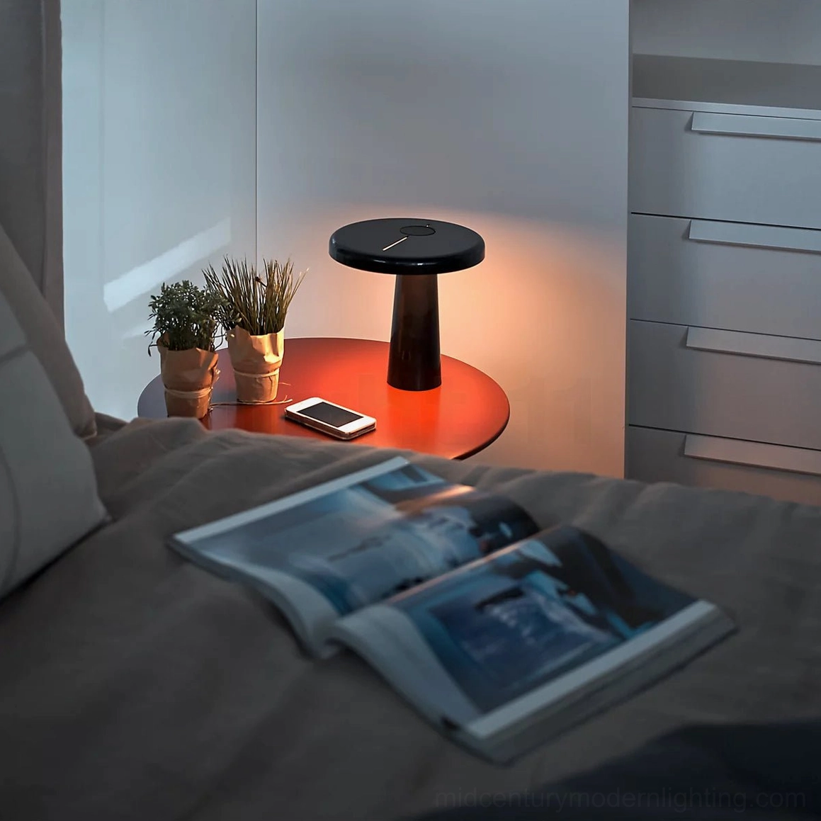 Hoop LED table lamp with warm lighting on bedroom bedside table next to potted plant, cozy modern aesthetic