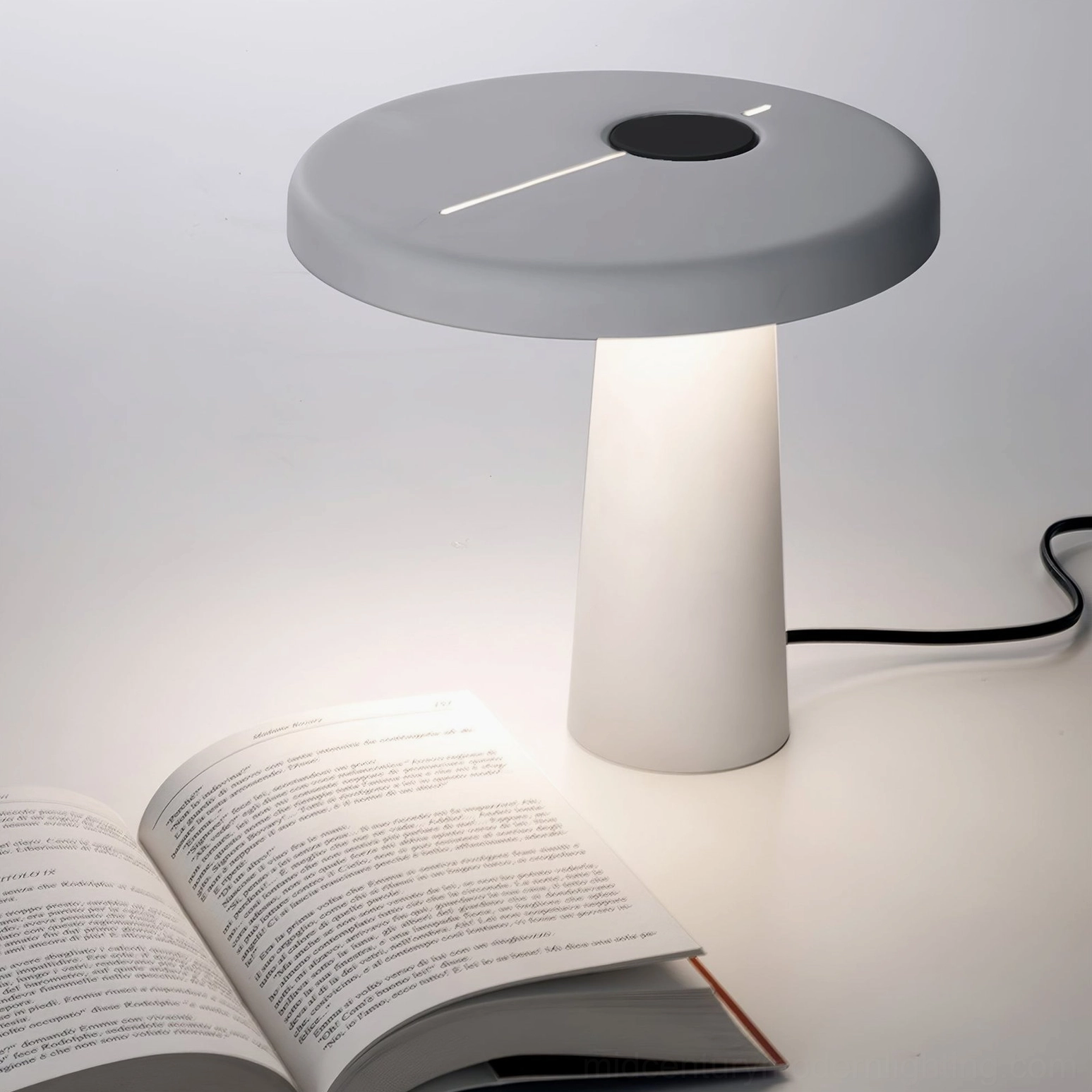 Modern Hoop LED table lamp in two-tone gray and white sitting on desk with open book, minimal workspace