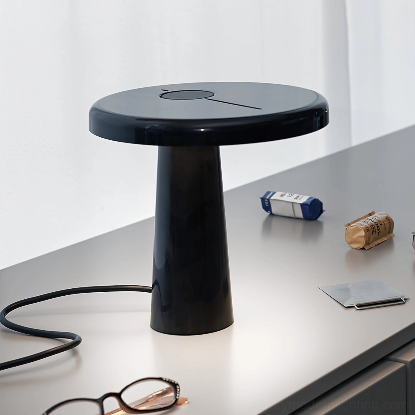 Hoop LED table lamp with asymmetrical pole on minimalist desk with stationery and glasses, contemporary design