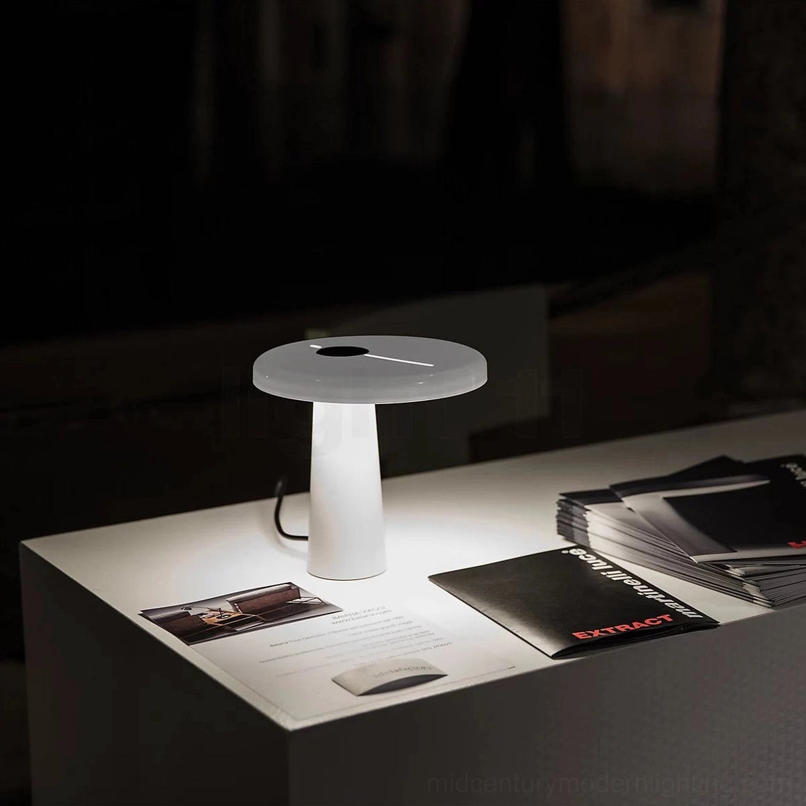White glossy Hoop LED table lamp on nightstand with stationery and books, warm light 3000K illumination