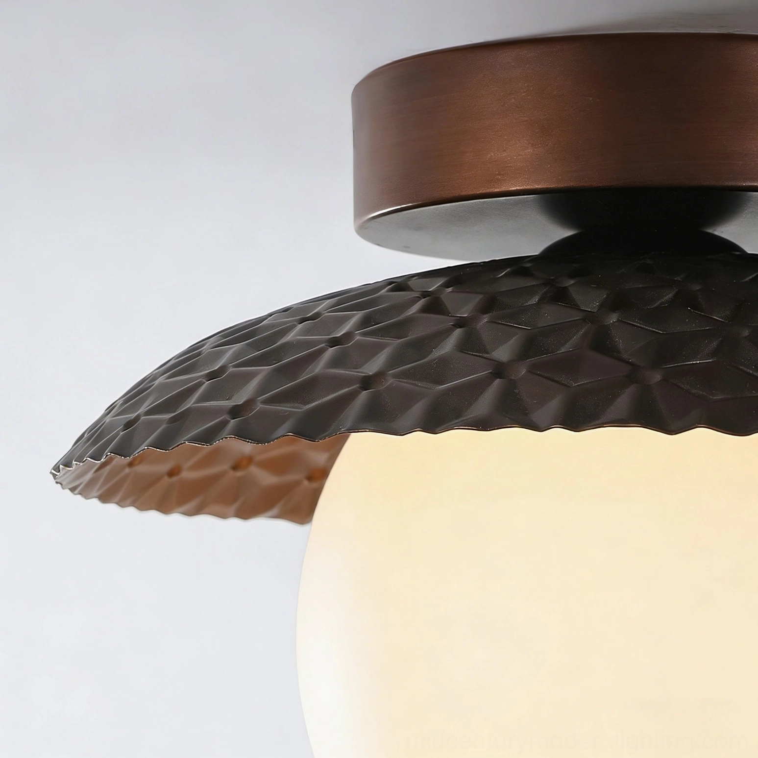 Extreme close-up of Hooper lamp showcasing detailed hammered metal rim texture and copper-finished acrylic light diffuser