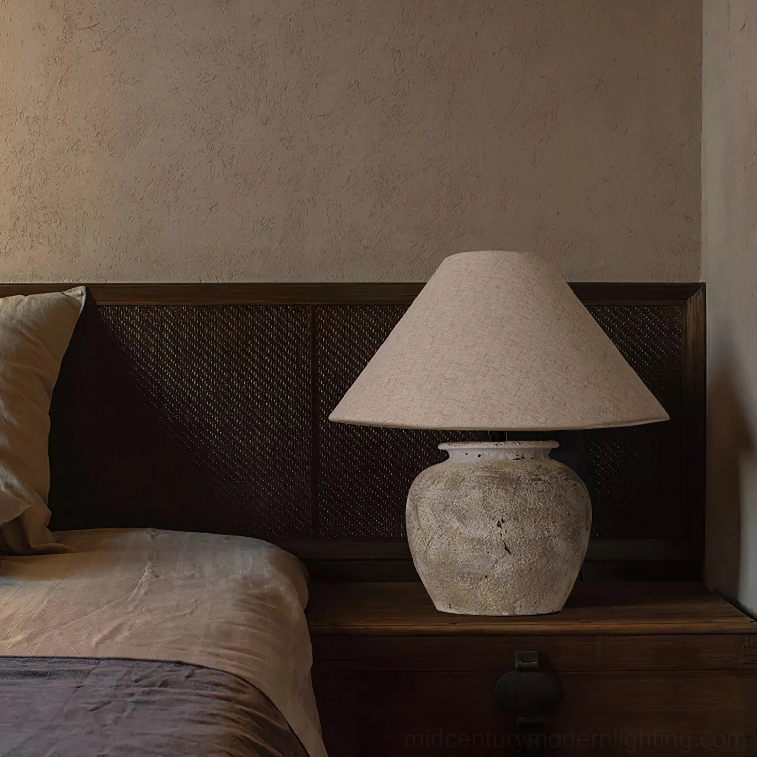 Houa ceramic table lamp on dark wood bedside table in warm bedroom setting