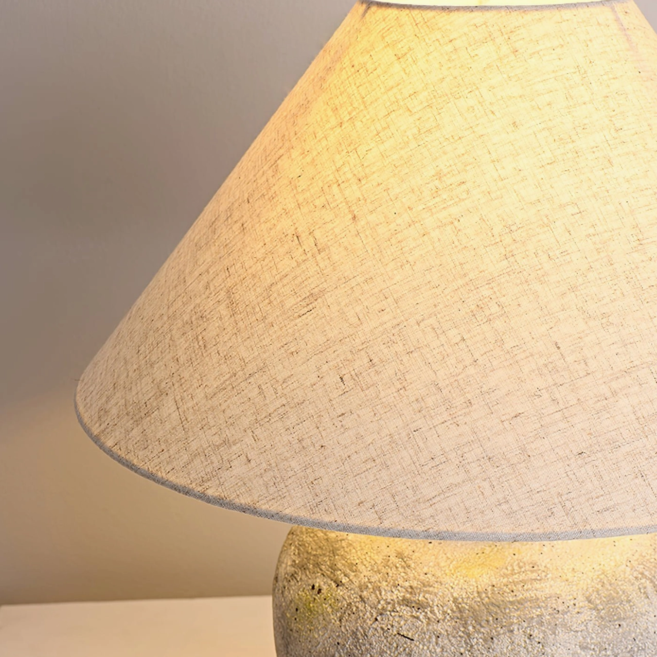 Detailed view of Houa ceramic lamp's natural linen shade texture and light diffusion